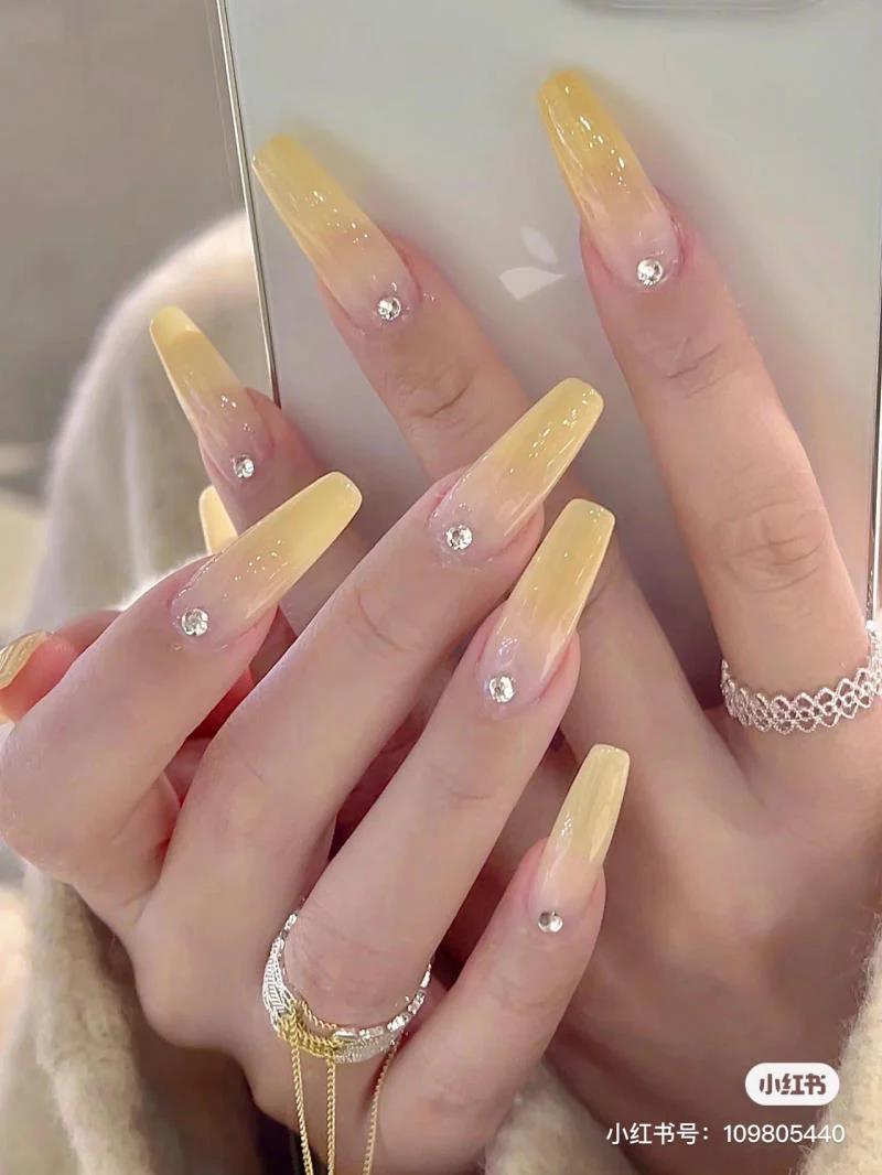 Nail màu vàng ombre đính đá thanh lịch